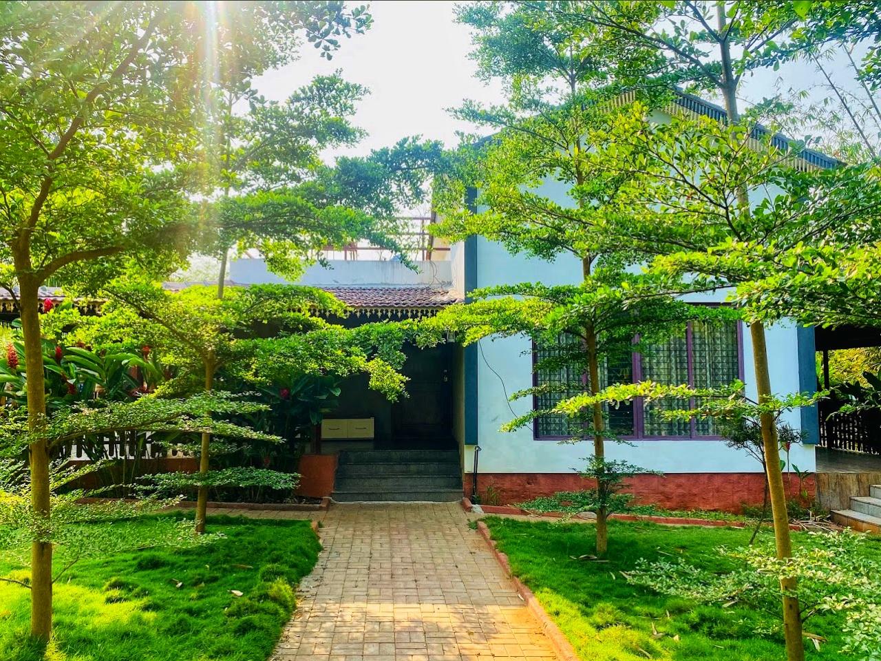 Villa entrance framed by manicured trees and gardens