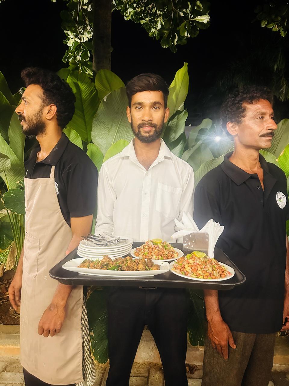 Service staff presenting starter platters at an evening event